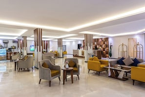 A hotel lobby with seating areas, a reception desk, and a TV screen. - Al Qasr Al Maseef Khamis Mushit (Khamis Mushait)