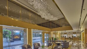 A spacious lobby with a high ceiling, a reception desk, and seating areas. - Grand Continent Luxury Collection, Udaipur (Udaipur)