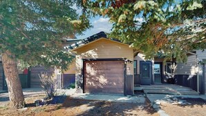 A single-story house with a garage, a covered porch, and a well-maintained front yard. - Stylish townhouse with WiFi, private washer/dryer, patio, and full kitchen (Big Sky)