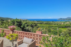 A terrace with outdoor furniture, a decorative railing, and a view of the sea and greenery. - Panoramic villa overlooking the Gulf of Portoferraio (Portoferraio)