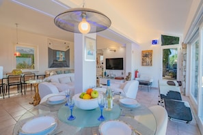 A dining area with a round table, chairs, and a bowl of fruit. - Panoramic villa overlooking the Gulf of Portoferraio (Portoferraio)