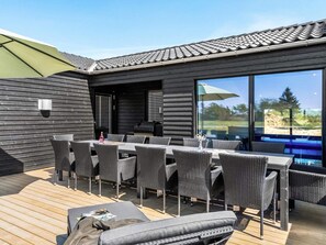 An outdoor patio with a dining table and chairs, a grill, and a view of a swimming pool. - 5 Star Holiday Home in Hjorring (Hjørring)