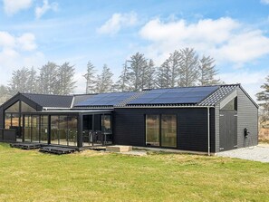 A modern house with a solar panel roof, large windows, and a covered patio area. - 5 Star Holiday Home in Hjorring (Hjørring)