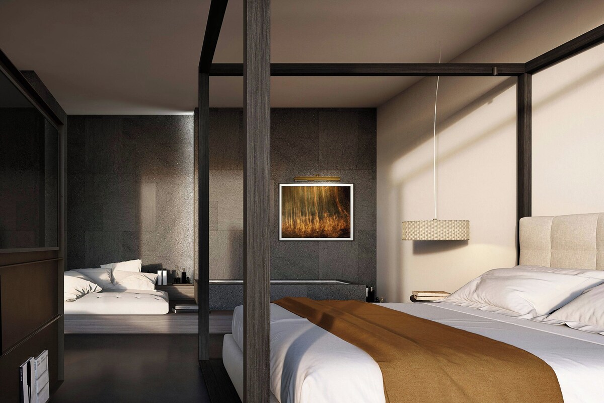 Ein modernes Schlafzimmer mit Baldachinbett, einem separaten Badezimmer und einem großen Kunstwerk an der Wand.