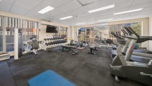 Una palestra con tapis roulant, manubri e attrezzature per esercizi.