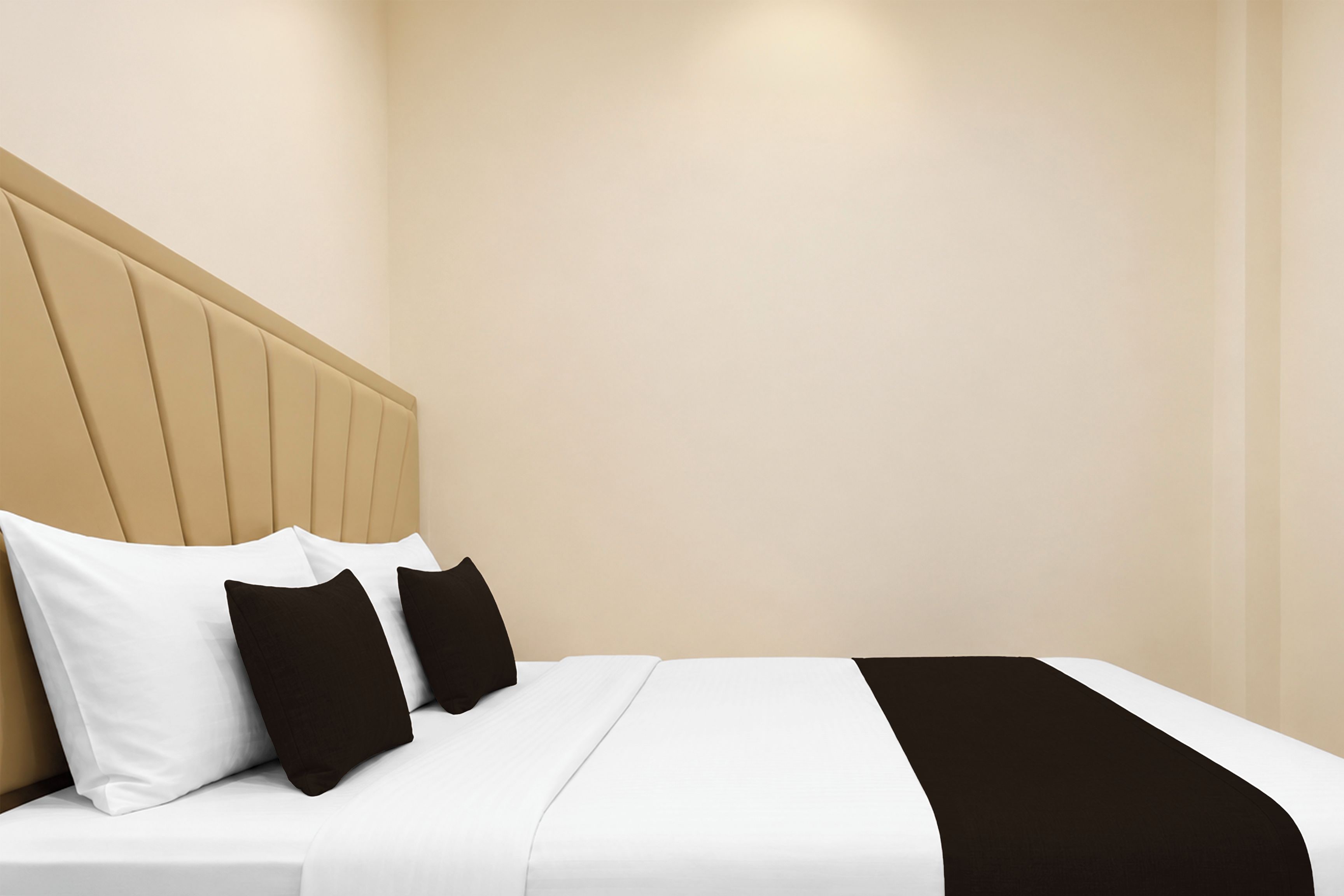 Una habitación de hotel con cama, almohadas y cabecera.