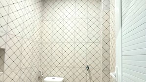 Une petite salle de bain comprenant des toilettes, un lavabo et un espace douche.