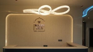 Un mostrador de recepción de diseño moderno, con un cartel encima y un techo con iluminación empotrada.