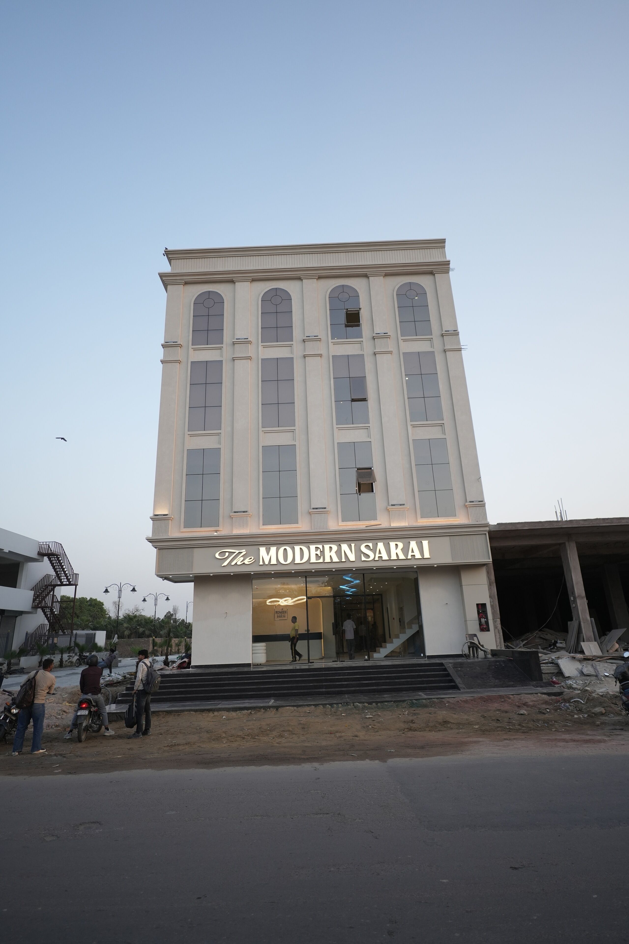 Un edificio de varios pisos con un letrero llamativo que dice 'The Modern Sarai'.