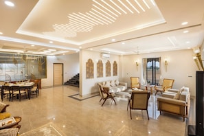 Amplia sala de estar con comedor, sofás y televisor.