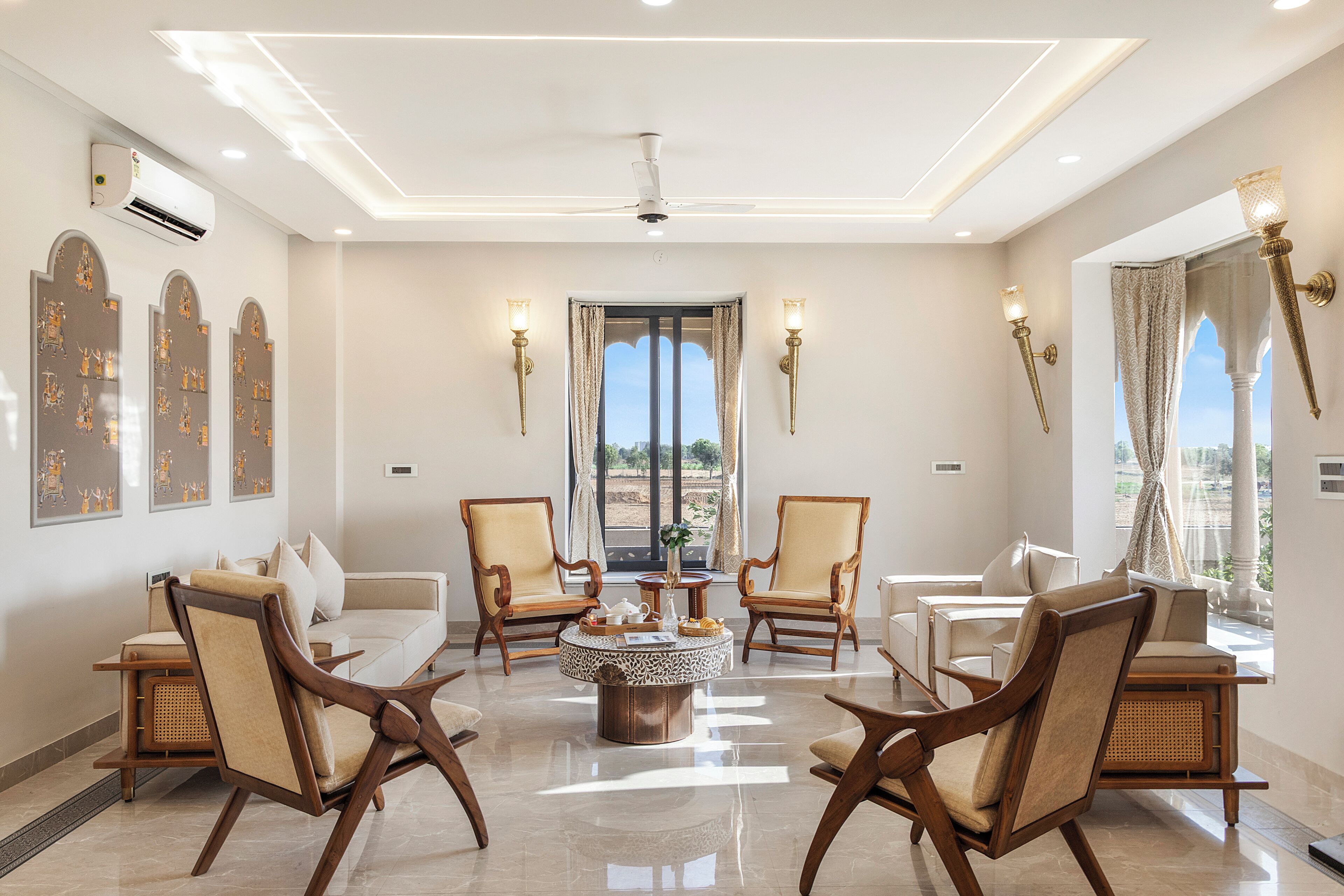 Una habitación amplia con una mesa de centro, cuatro sillas, un sofá y un ventanal con cortinas.