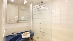 A bathroom with a glass shower enclosure, a blue sink, a mirror, and a glass shelf above the sink. - R Sidence R sid Price St6n (Merville)