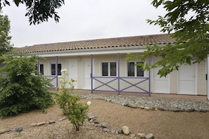 A building with a tiled roof, white walls, and a gravel driveway. - R Sidence R sid Price St6n (Merville)
