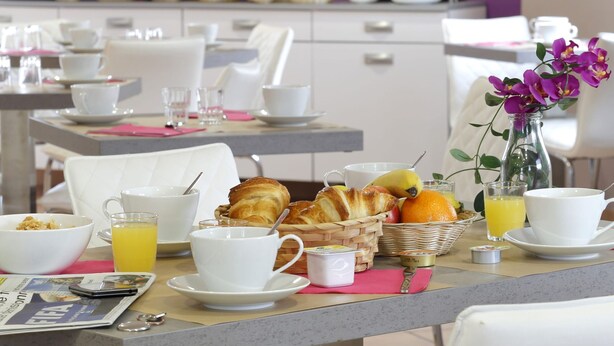 A breakfast setting with tables, chairs, and a variety of food items. - R Sidence R sid Price St6n (Merville)