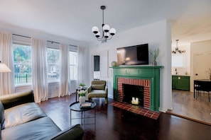 Ein Wohnzimmer mit Kamin, Fernseher und Essbereich.