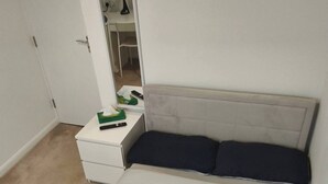 A bedroom with a bed, a nightstand, a mirror, and a closet. - Room-small Double in Quiet House - Chelm (Chelmsford)