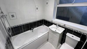 A bathroom with a bathtub, a sink, and a toilet. - Room-small Double in Quiet House - Chelm (Chelmsford)