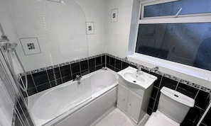 A bathroom with a bathtub, a sink, and a toilet. - Room-small Double in Quiet House - Chelm (Chelmsford)