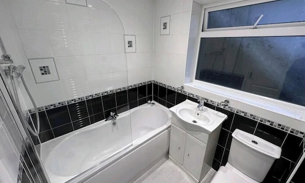A bathroom with a bathtub, a sink, and a toilet. - Room-small Double in Quiet House - Chelm (Chelmsford)