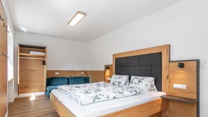 Un dormitorio moderno con estructura de cama de madera, armario empotrado y mesita de noche.