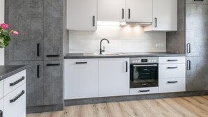 A modern kitchen with white cabinets, a Bosch oven, and a grey countertop. - Dreamlike vacation apartment with sunny terrace. (Wildschönau)