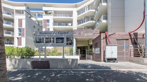 A multi-story hotel with balconies, a signboard for 'Résidence Le Crystal,' and a gated entrance. - R Sidence Le Crystal 3p6s (Cagnes-sur-Mer)