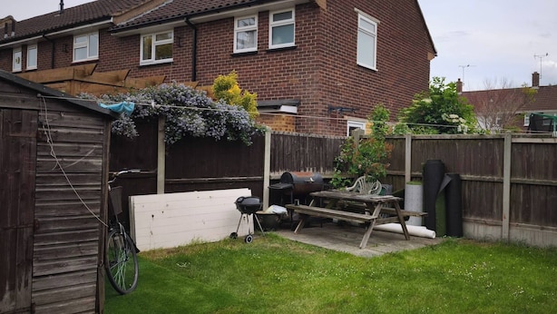 A backyard with a wooden fence, a barbecue grill, a bicycle, and a shed. - Room-small Cozy Room in Chelmsford Sprin (Chelmsford)
