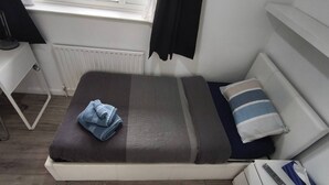 A small, neatly arranged bedroom with a bed, a desk, and a chair. - Room-small Cozy Room in Chelmsford Sprin (Chelmsford)