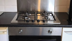 A kitchen with a stainless steel range hood, a gas stove, and an oven. - Room-small Cozy Room in Chelmsford Sprin (Chelmsford)