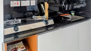 Une cuisine moderne avec des armoires blanches, un comptoir noir et une cuisinière intégrée.
