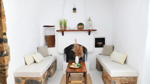 A cozy living room with a fireplace, two sofas, a coffee table, and decorative items. - Cozy 1-bedroom apartment in charming Kalymnos with AC (Kalymnos)