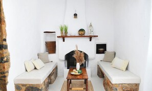 A cozy living room with a fireplace, two sofas, a coffee table, and decorative items. - Cozy 1-bedroom apartment in charming Kalymnos with AC (Kalymnos)