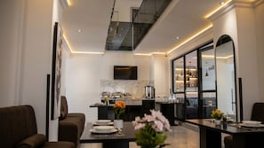 A modern kitchen with a marble backsplash, a dining area with a table set for two, and a staircase leading to an upper level. - Regent Heights Hotel (Ruiterhof, Sandton)
