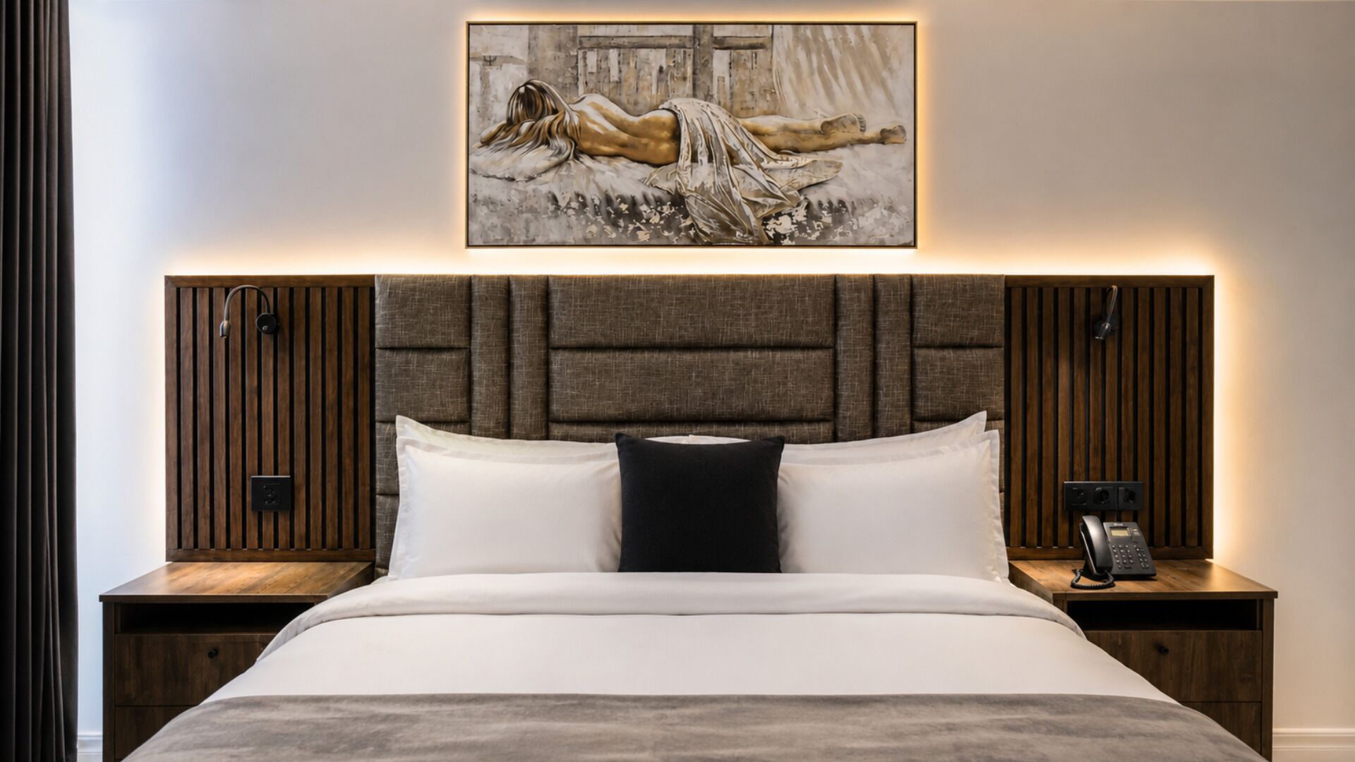 A bedroom with a bed, two nightstands, a wall-mounted phone, and a painting above the bed.