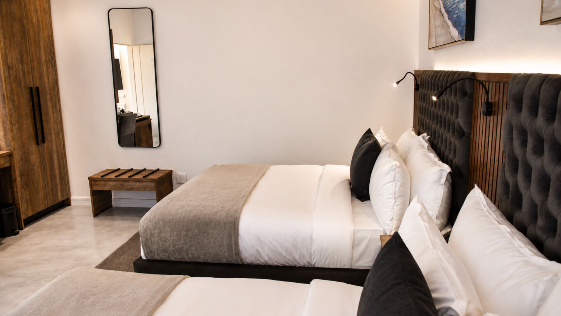 A bedroom with a bed, bedside table, and a mirror.