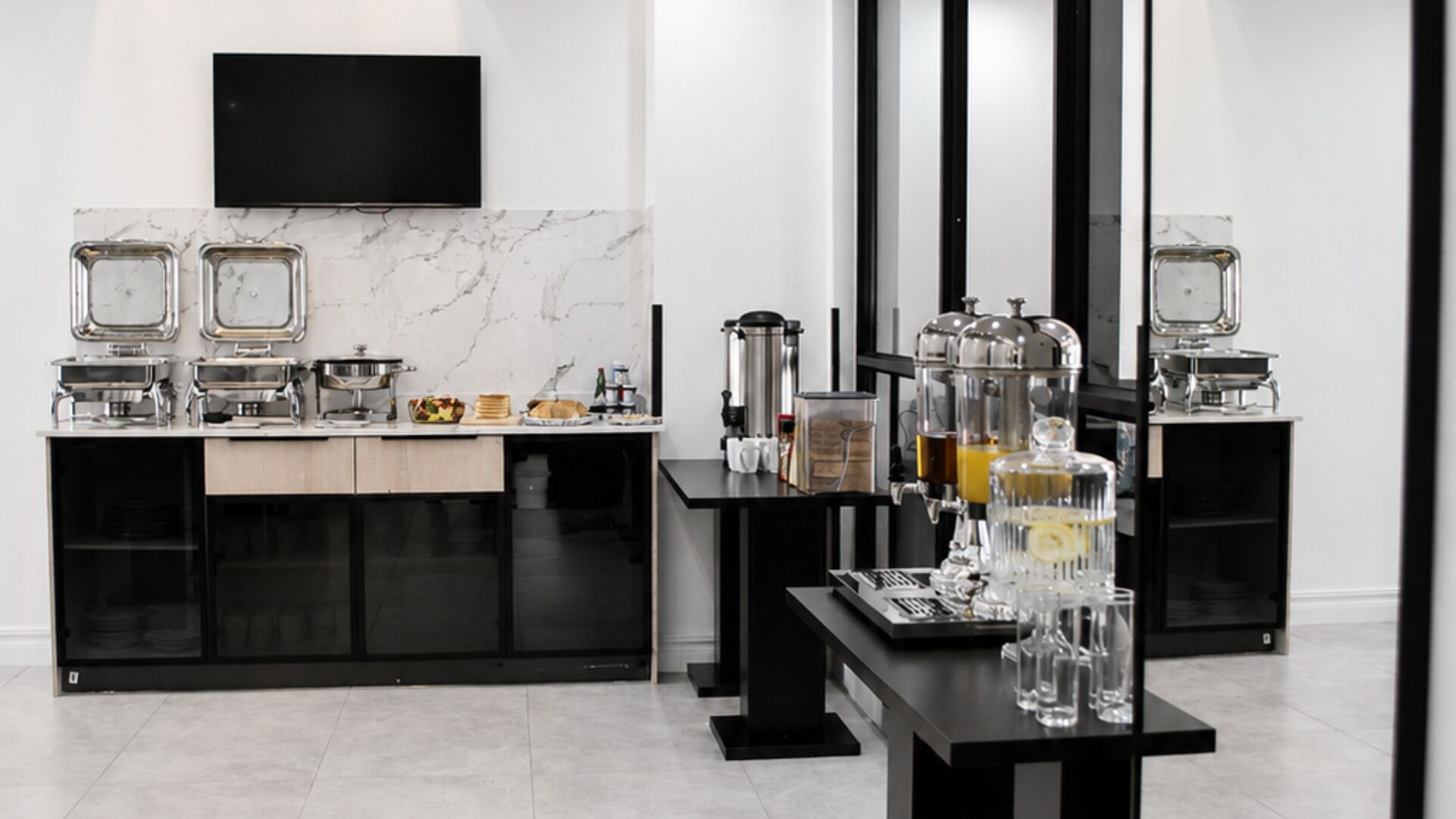 Una cocina moderna con televisor de pantalla plana, máquinas de espresso y una estación de café.