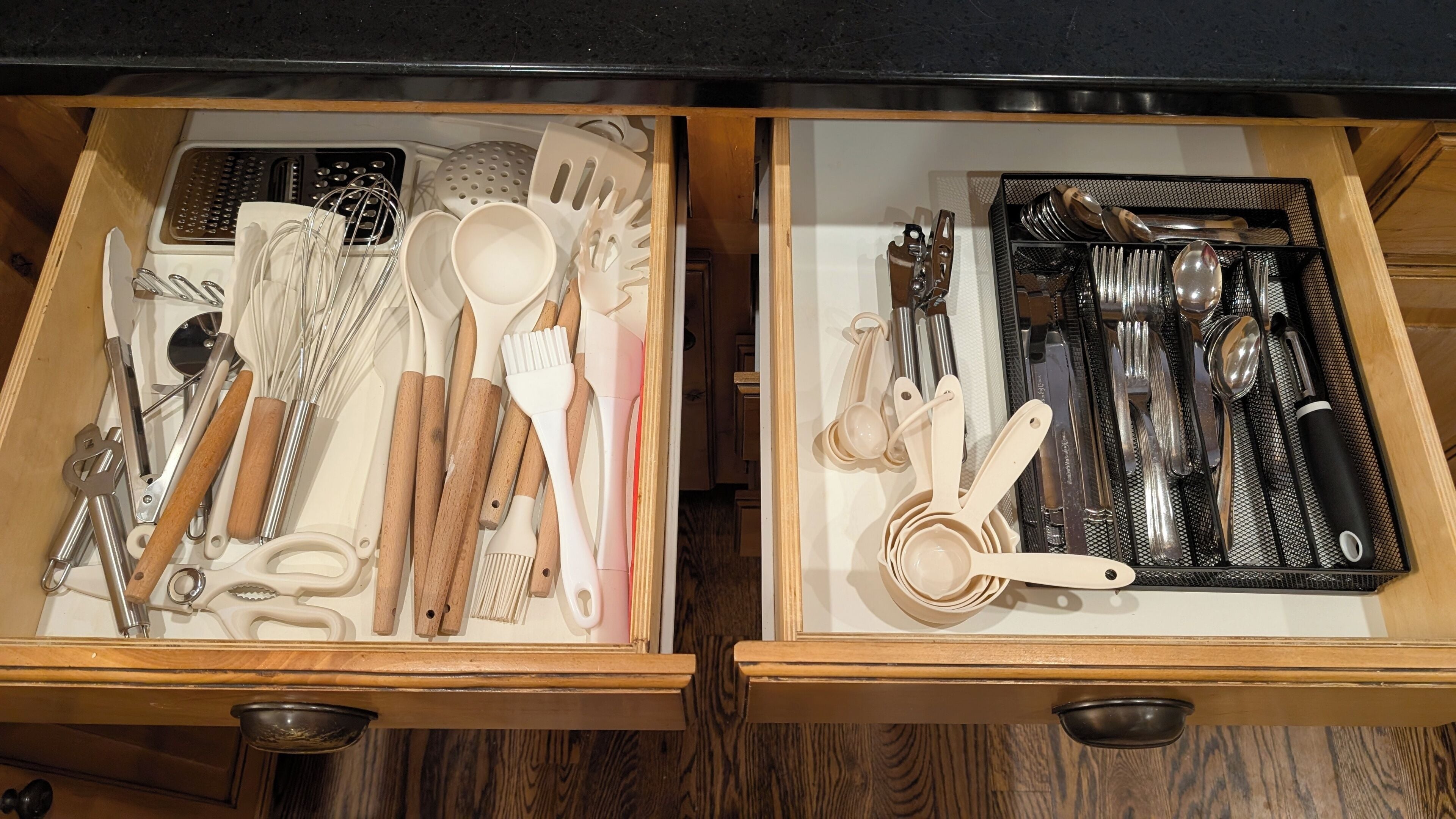 A drawer with kitchen utensils and tools, including whisks, spatulas, and measuring spoons.