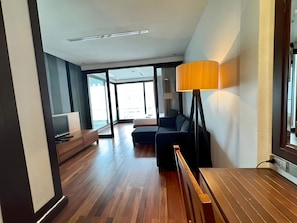 A modern hotel room with a large window, a sofa, a desk, and a lamp. - Wish Inn Silom (Bangkok)