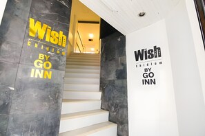Uma escadaria com uma placa que diz 'Wish by GO INN'.