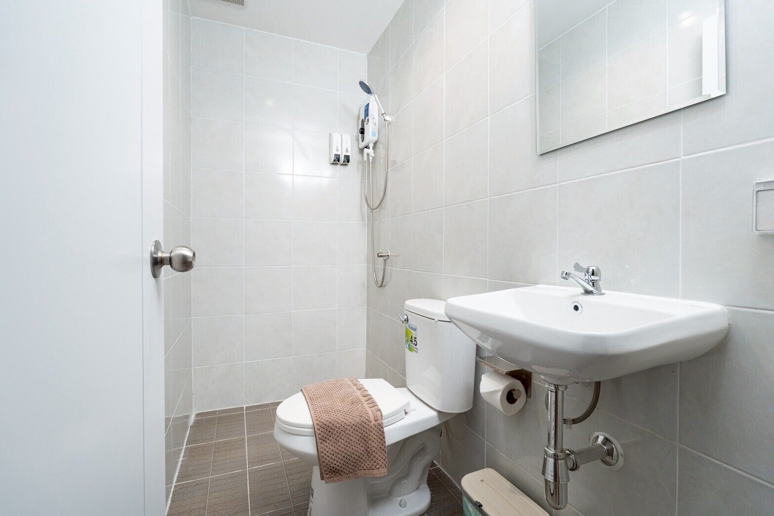 A bathroom with a toilet, sink, and shower.
