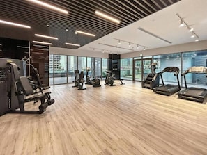 Ein Fitnessstudio mit diversen Trainingsgeräten, großen Fenstern und modernem Design.