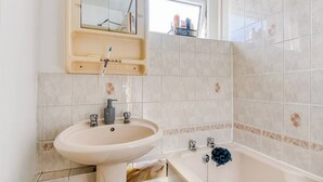 Un bagno con lavandino, specchio e vasca da bagno.