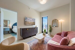 A modern living room with a sofa, a coffee table, and a TV mounted on the wall. - Top-Floor Wynwood Stay with Rooftop Pool N811 (Miami)