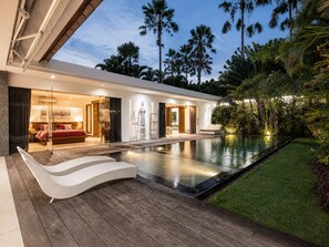 A modern house with a swimming pool, wooden deck, and tropical plants. - Elegant 3BR Oasis in the Heart of Seminyak (Seminyak)