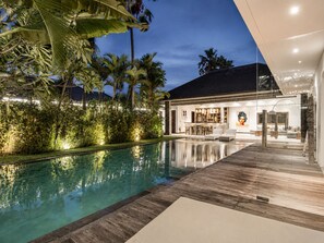 A modern house with a swimming pool, a bar area, and lush greenery. - Elegant 3BR Oasis in the Heart of Seminyak (Seminyak)