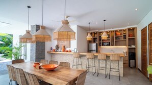 A modern kitchen with a central island, bar stools, and pendant lighting. - Canggu Coastal Living: 4BR Villa Near Finns (Canggu)