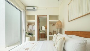 Ein Schlafzimmer mit einem großen Bett, einem Kleiderschrank, einem Spiegel und einer Hängeleuchte.