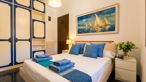 A hotel room with a bed, a nightstand, a painting of sailboats, and a blue decorative wall panel. - 15 min. drive from Sitges Villa El Ranch 10 min. walk to the beach Jacuzzi 14P (Sitges)