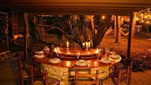 An outdoor dining area with a stone table, wooden chairs, and candles. - 15 min. drive from Sitges Villa El Ranch 10 min. walk to the beach Jacuzzi 13P (Sitges)