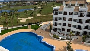 Ein Hotel mit Schwimmbad, Golfplatz und Bergblick.